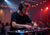 Jeune DJ homme en action avec mixeur moderne lors d'une soirée