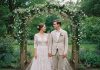 Le style au cœur du grand jour : inspirations pour un mariage unique Jeune couple de mariés dans un jardin avec arche en bois