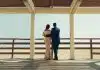 man and woman standing on wooden dock during daytime