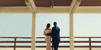 man and woman standing on wooden dock during daytime