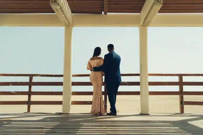 man and woman standing on wooden dock during daytime